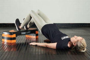 Woman doing hip bridges using a Mirafit Aerobic Exercise Step