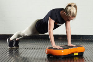 Woman doing a push up on a Mirafit Slimline Vibration Plate
