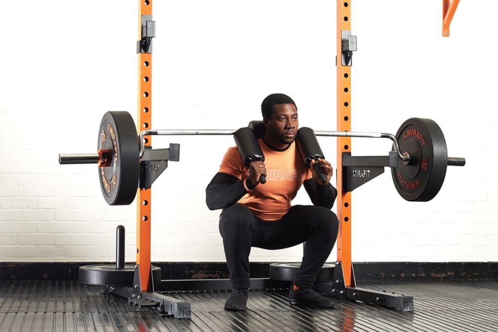 Mirafit M220 Squat Rack Man squatting in a Mirafit M220 Squat Rack