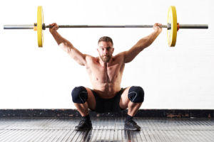 Man doing an overhead squat press with Mirafit 15kg weight plates