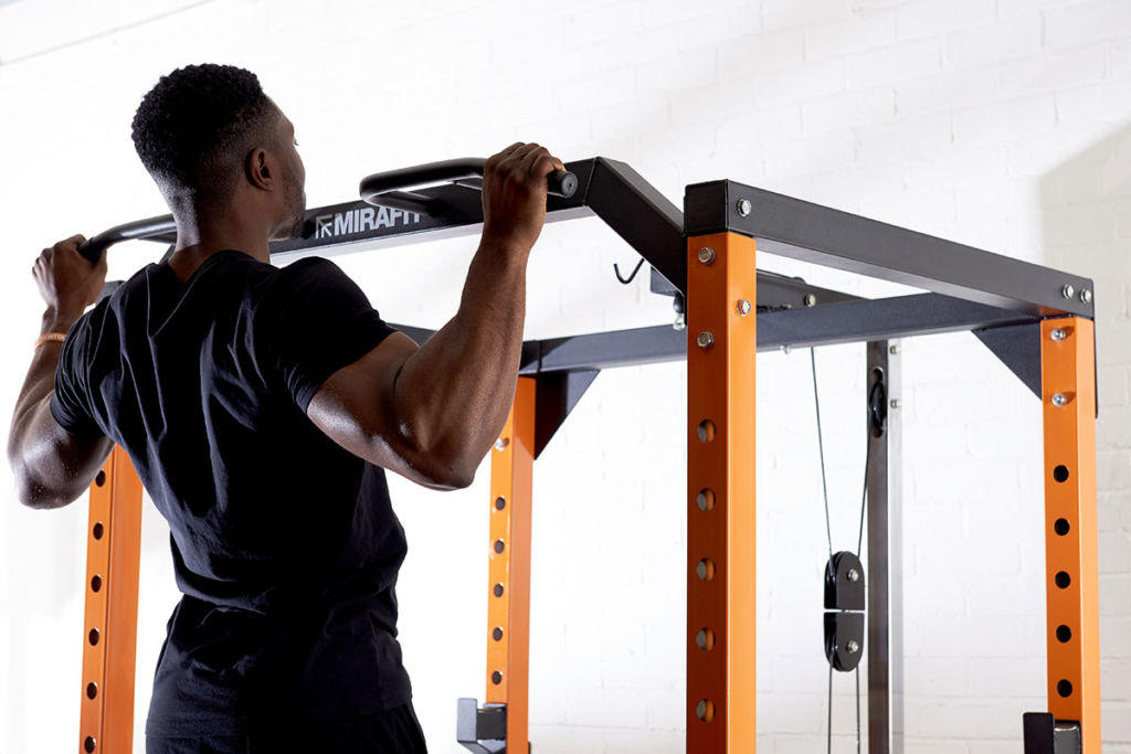 fitness expert does a chin up on a mirafit power rack