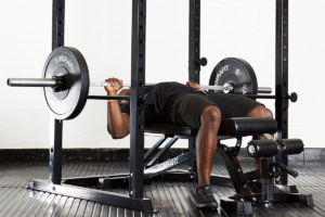 Man doing a bench press on a Mirafit M150 Adjustable Weight Bench