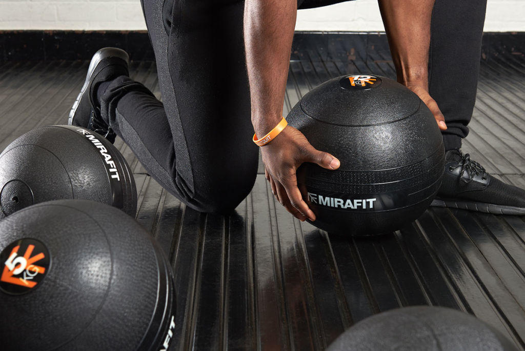 Mirafit Non Bounce Slam Ball - 12kg Slam Ball Man picking up a Mirafit Non Bounce 12kg Slam Ball
