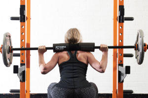 Woman squatting with a Mirafit Barbell Squat Pad