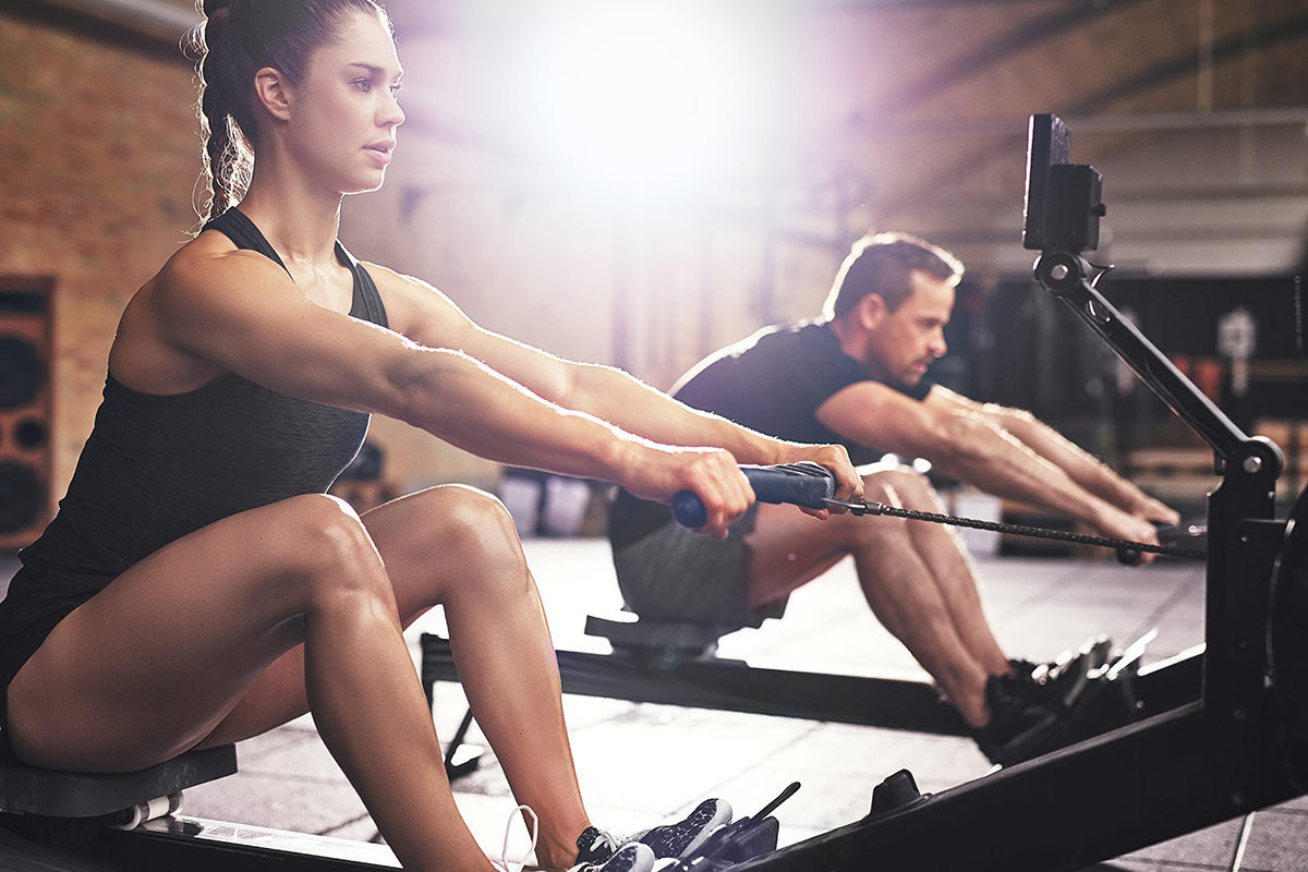 Rower Man and woman rowing at the gym
