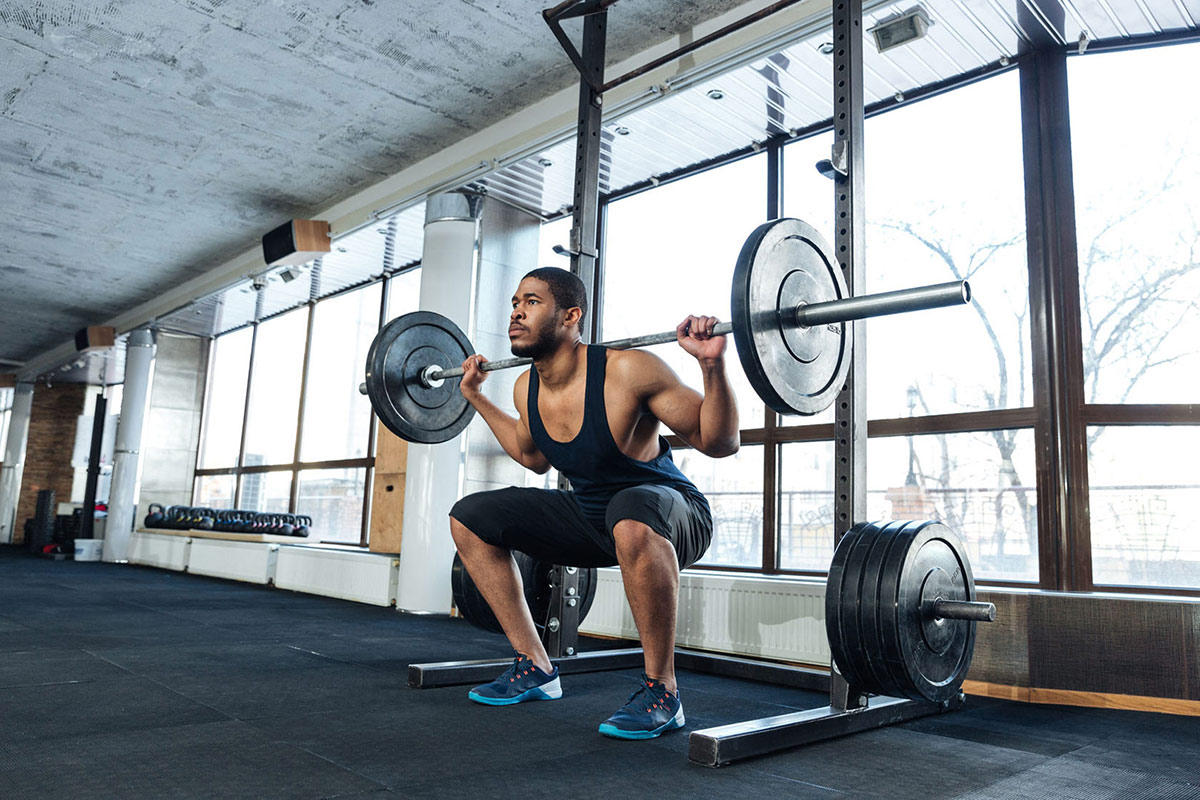 Man squatting with weight plates