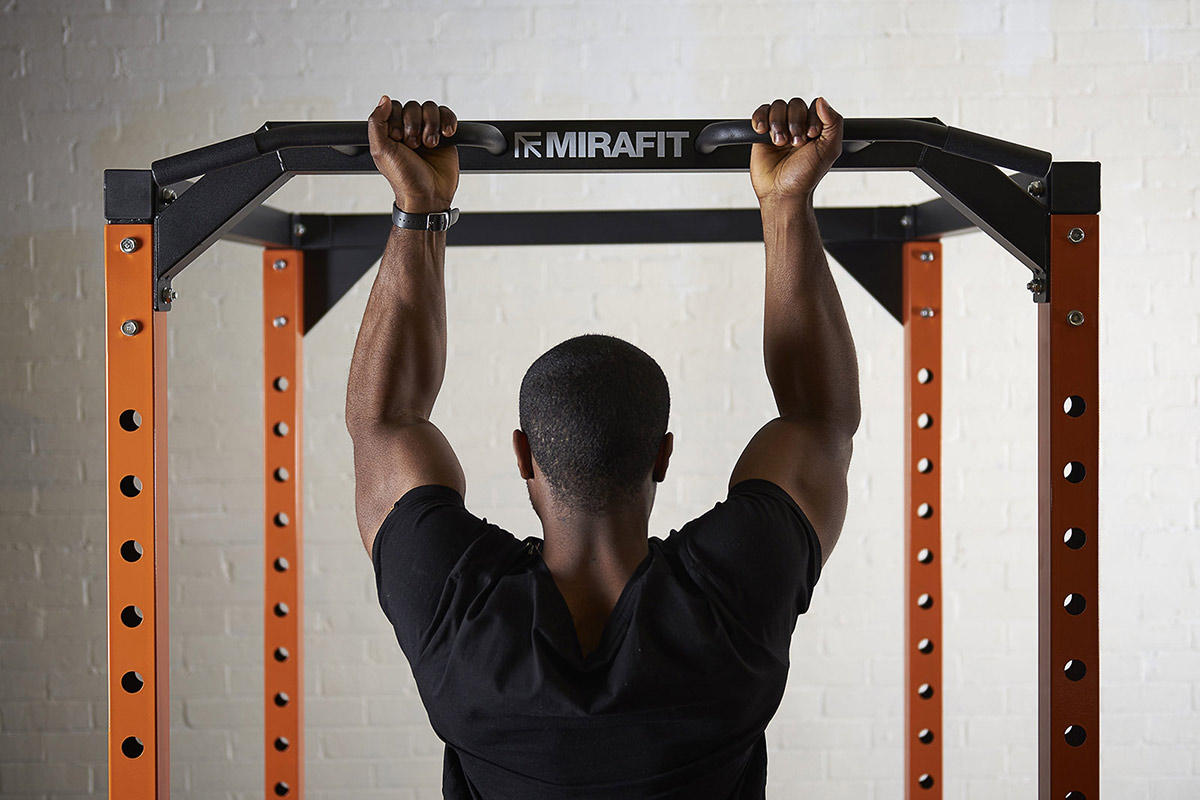 young man doing a chin up on a mirafit power cage