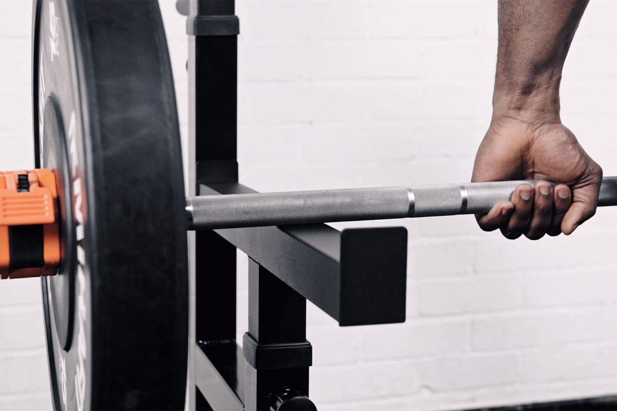 Man gripping a Mirafit Olympic Barbell
