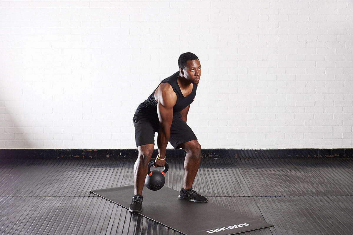 Kettlebell Clean and Press Man doing a kettlebell clean and press using a Mirafit Cast Iron Kettlebell