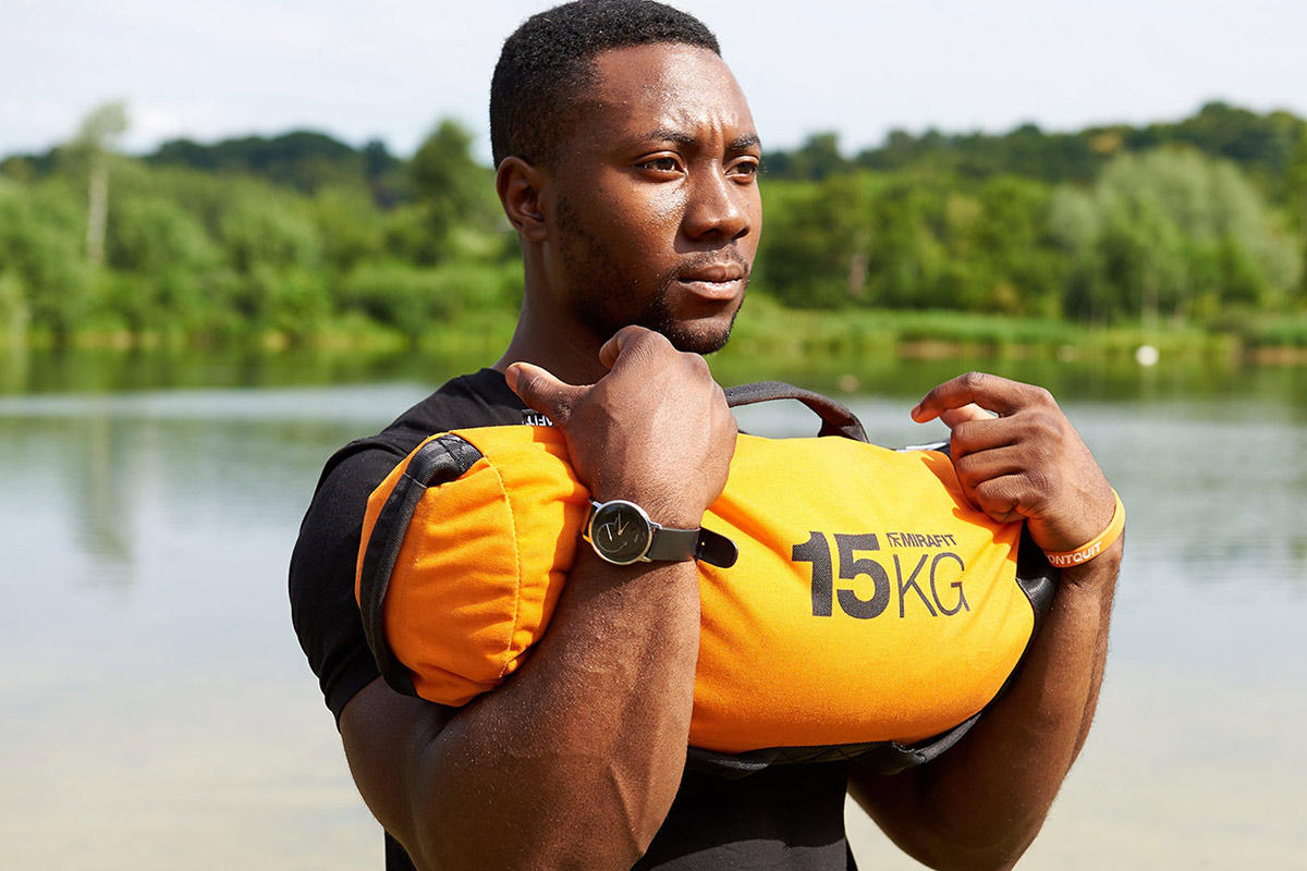 Sandbag Carry Man performing a sandbag carry with a Mirafit Gym Sandbag