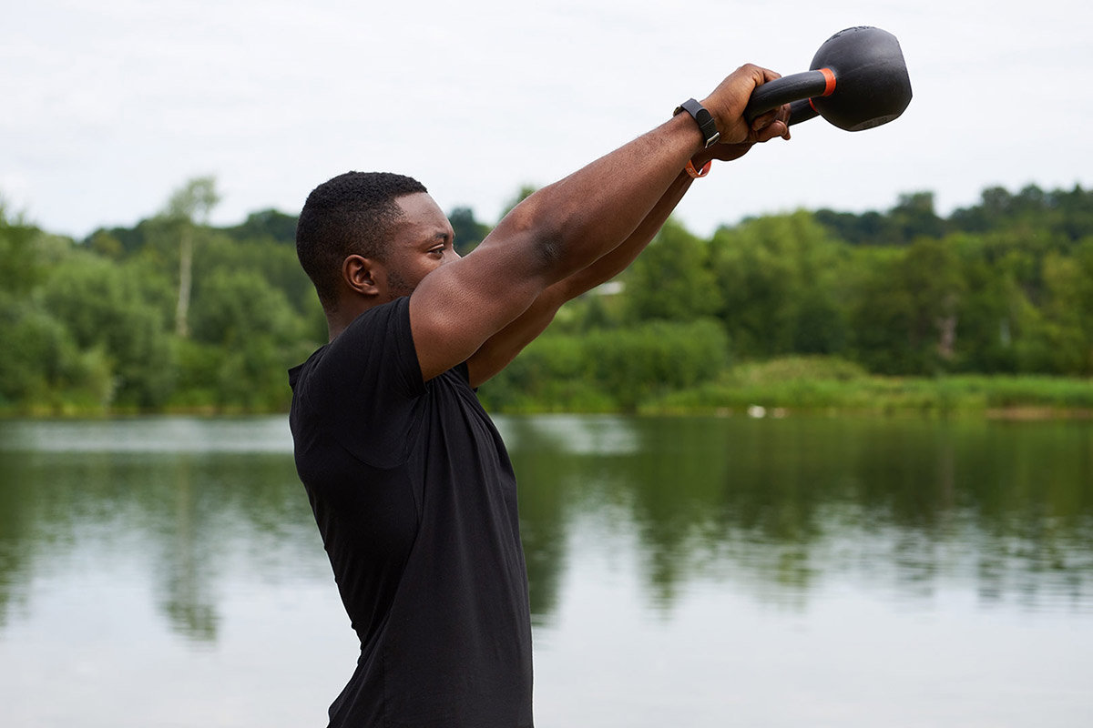 Mirafit Cast Iron Kettlebell Man doing a kettlebell swing with a Mirafit Cast Iron Kettlebell