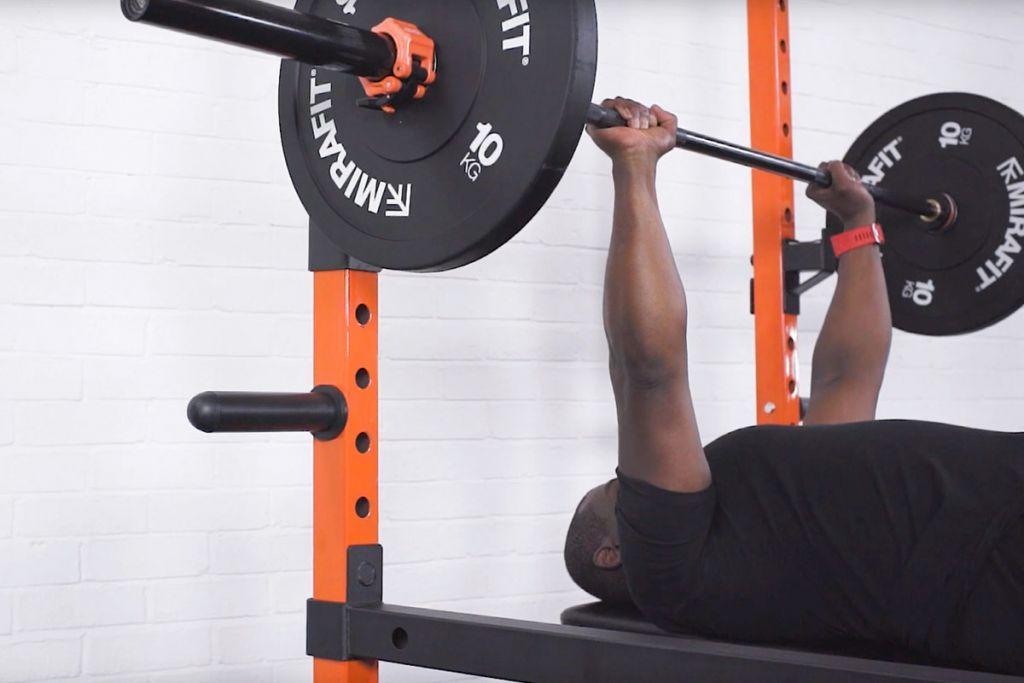 Mirafit Black Olympic Rubber Bumper Plates - 10kg Plates Man bench pressing with Mirafit 10kg Weight Plates