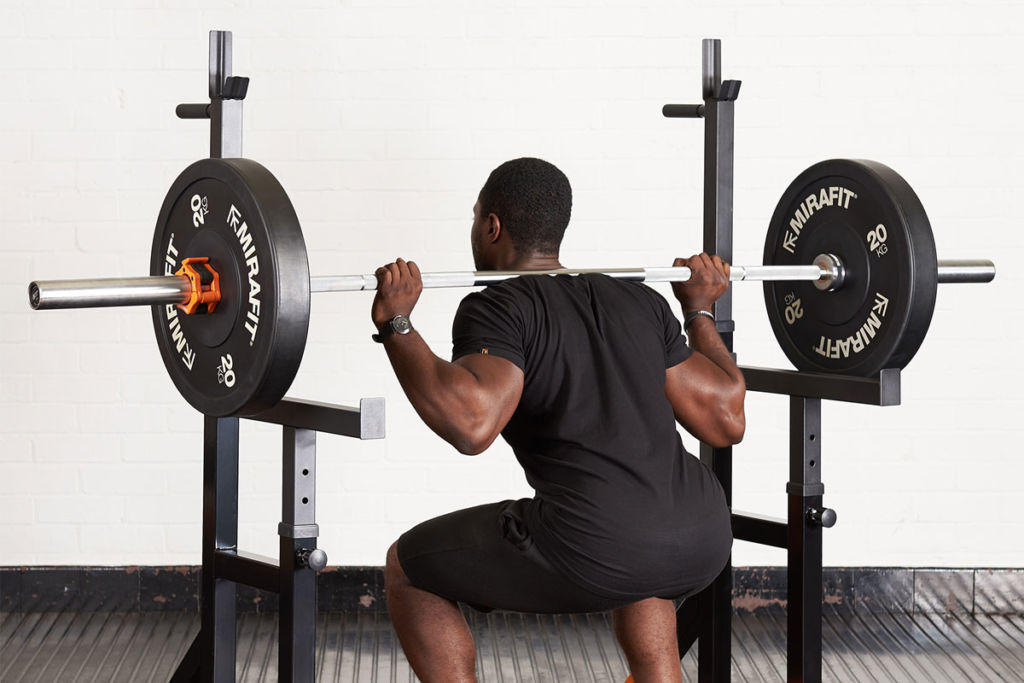 Fitness expert using a Mirafit adjustable squat rack