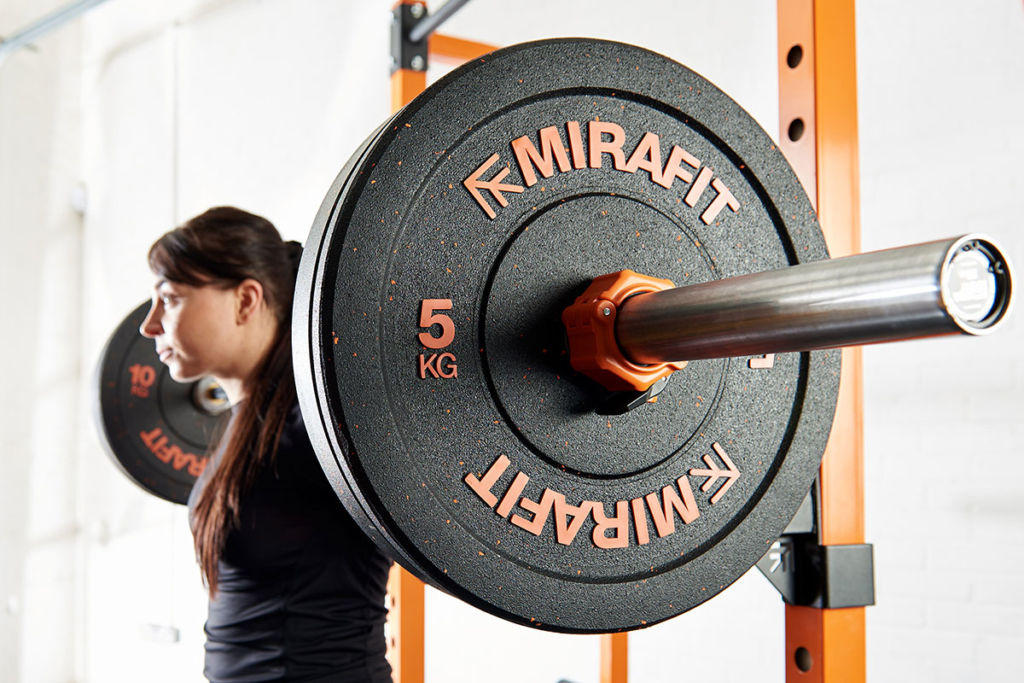 Woman squatting with 5kg weight plates