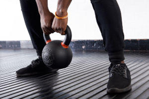 mirafit fitness expert trains with a cast iron kettlebell