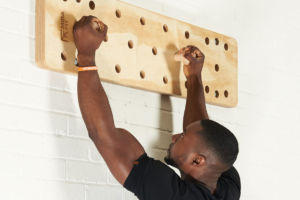 Man using a Mirafit Climbing Peg Board to hang