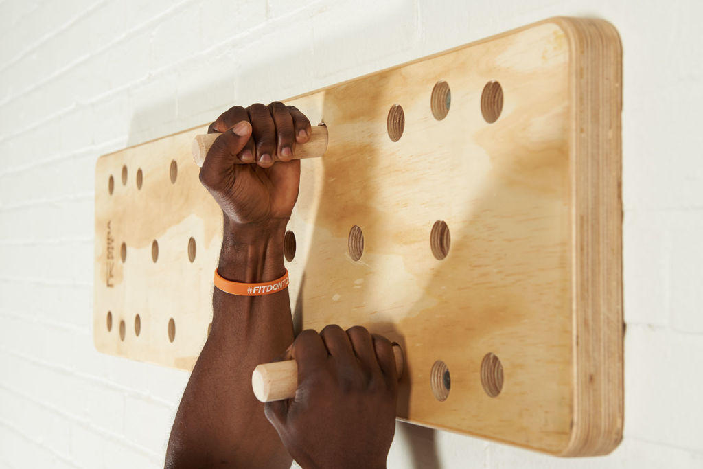 Mirafit Climbing Peg Board fitness expert uses a Mirafit Climbing Peg Board to do a staggered pull up