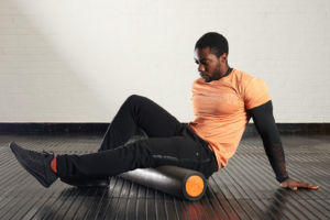 Man exercising with a Mirafit EPE Foam Roller