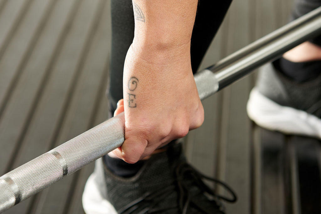 Mirafit M3 Women's 15kg Olympic Barbell Woman gripping a Mirafit Women's Barbell