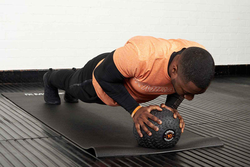 Push up Man doing a push up with a Mirafit Tyre Tread 10kg Slam Ball