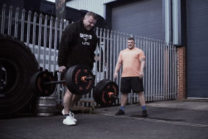 World's Strongest Man Tom Stoltman doing a Farmers Walk with Mirafit Crumb Rubber Olympic Bumper Plates