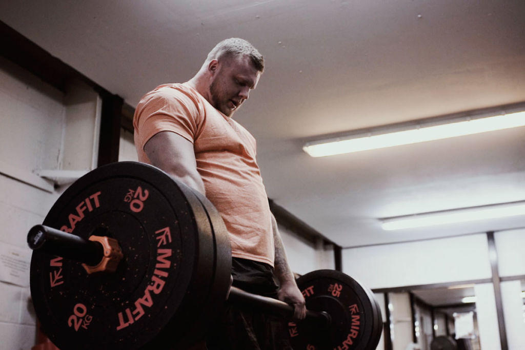 Mirafit Crumb Rubber Olympic Bumper Plates World's Strongest Man Tom Stoltman lifting a Mirafit barbell and 20kg weight plates
