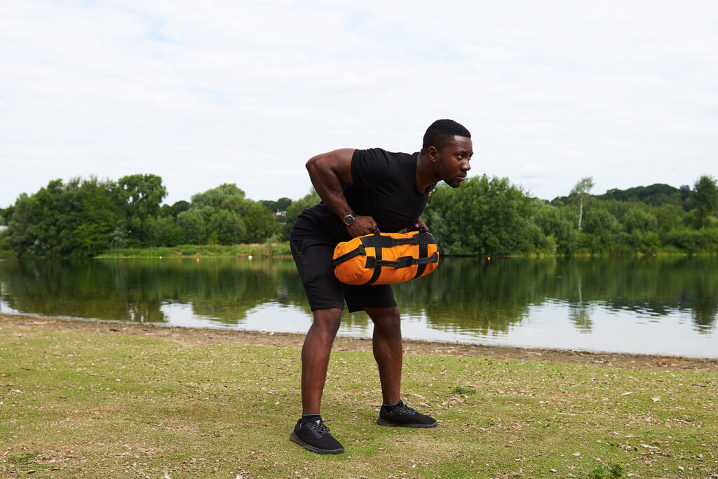 Mirafit Gym Sandbag man performing delt rows using a Mirafit Gym Sandbag