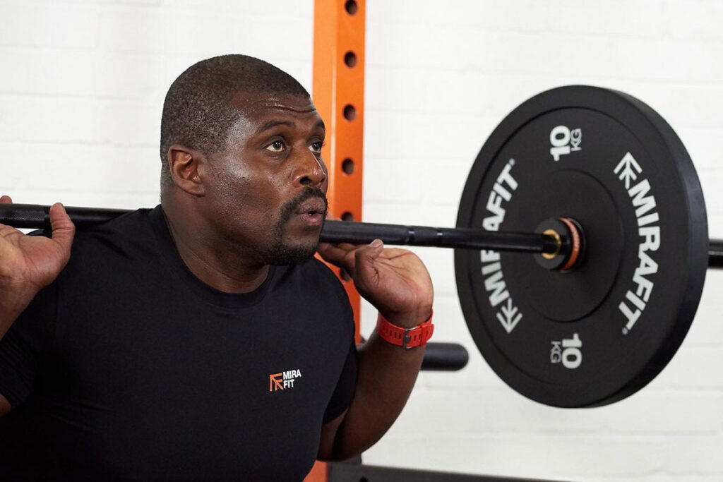 Man squatting with 10kg weight plates