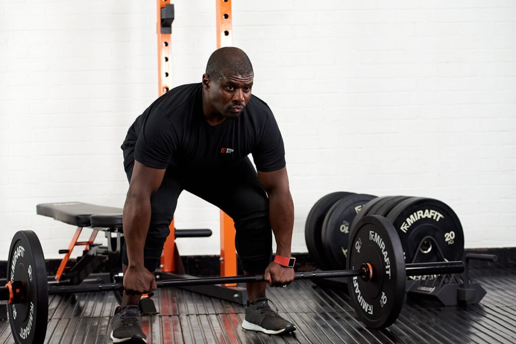 Mirafit Black Olympic Rubber Bumper Plates - 10kg weight plates Personal trainer and fitness expert Steve Parke preparing to deadlift with a Mirafit barbell, 10kg weight plates and collars