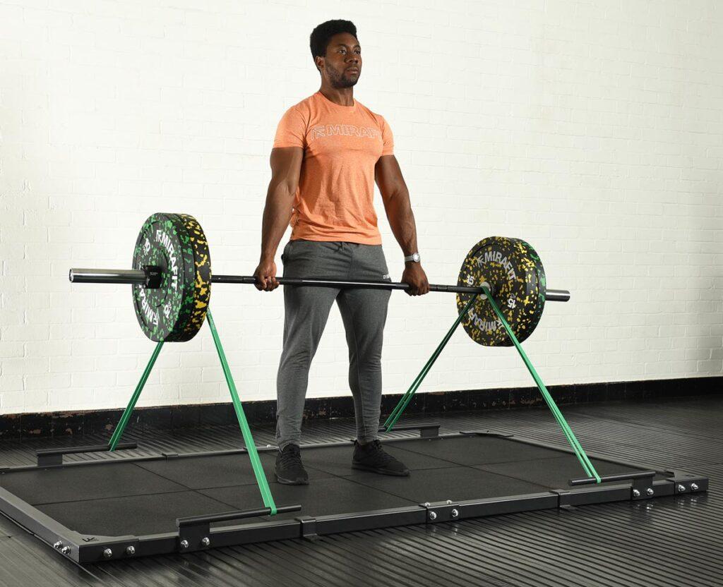 Mirafit Colour Splash Bumper Plates - 10kg weight plates and 15kg weight plates Man performing the deadlift exercise on a Mirafit deadlift platform with Mirafit Resistance Bands, 10kg weight plates and 15kg weight plates