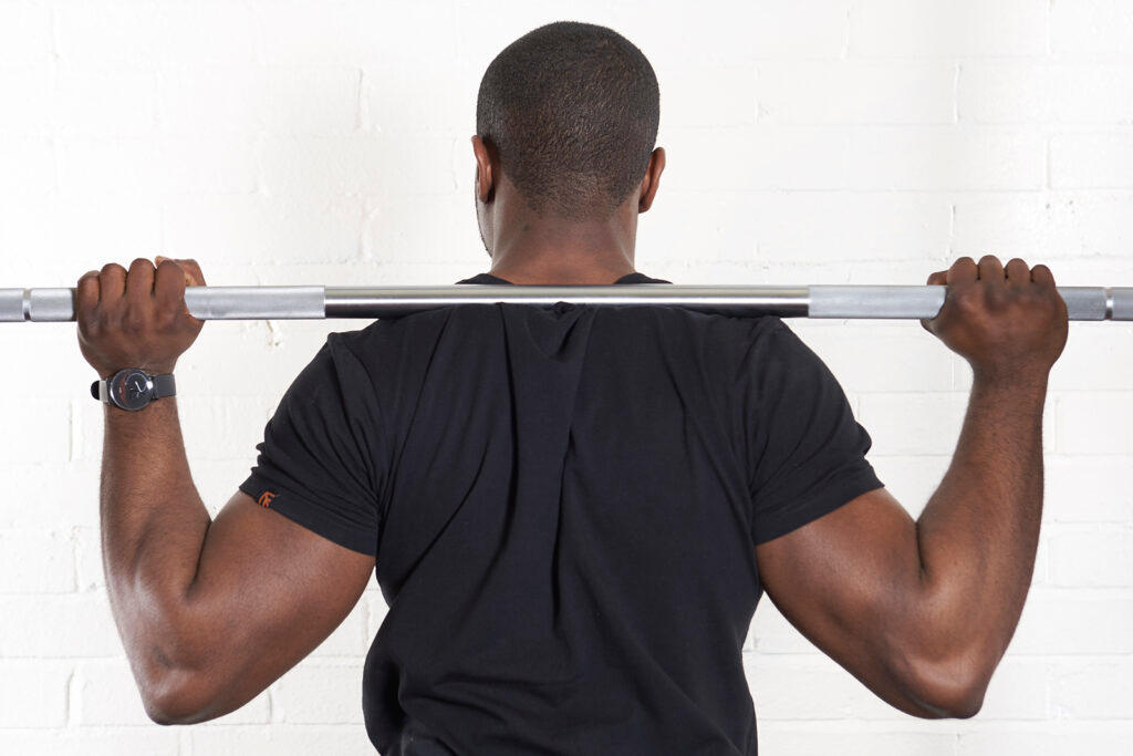 Mirafit M3 7ft 20kg Olympic Barbell Man showing hand position on a Mirafit Olympic Barbell before squatting
