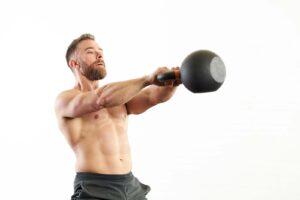 Man performing a kettlebell swing with a Mirafit Cast Iron Kettlebell