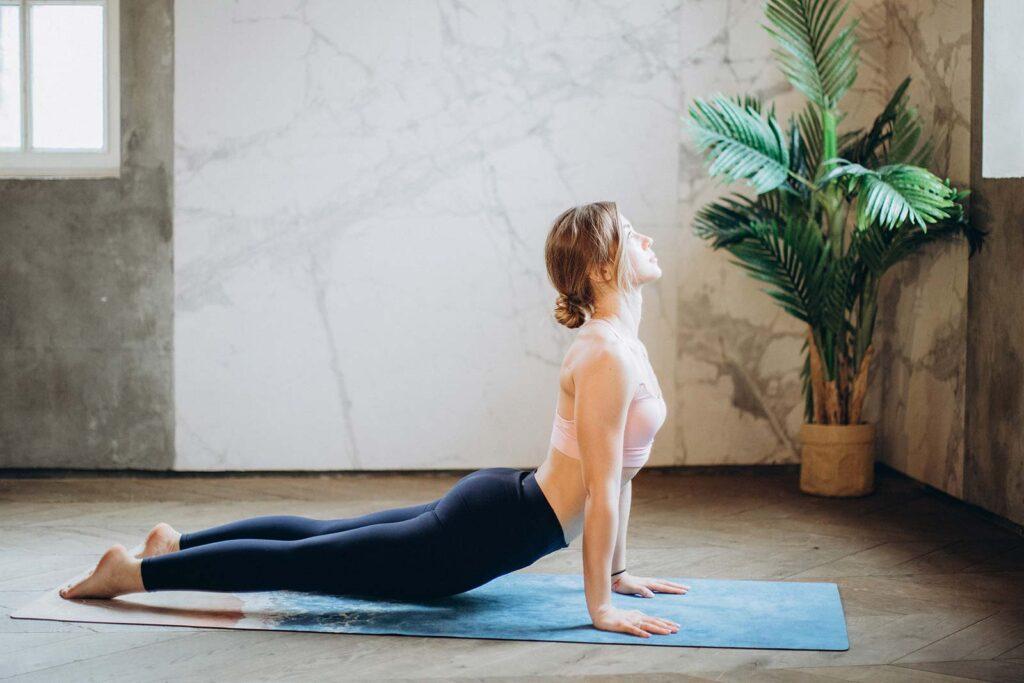 Cobra pose woman performing a yoga pose on a yoga mat