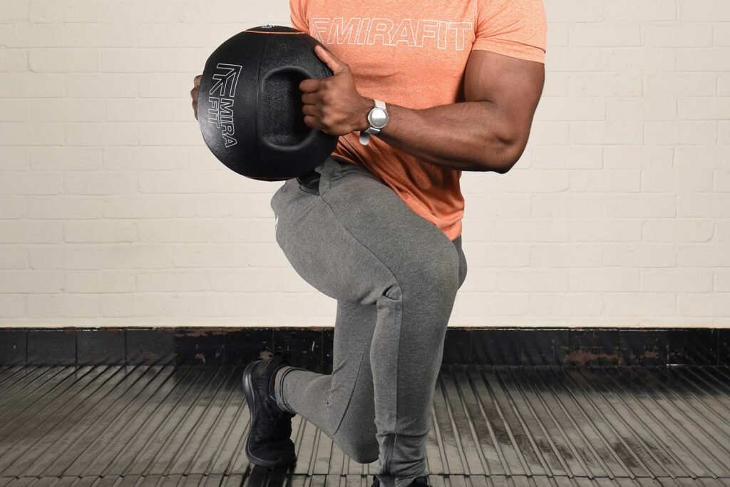 Twisting lunges Man Performing Twisting Lunges with Mirafit Double Handle Medicine Ball