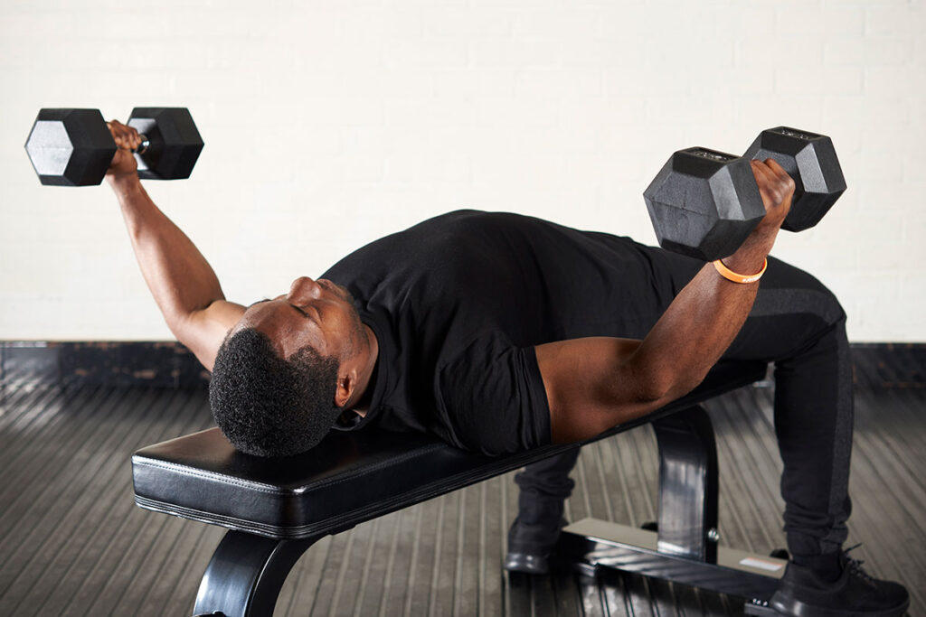 Mirafit Hex Dumbbells Man performing a dumbbell flye on a Mirafit weight bench with Mirafit Hex Dumbbells