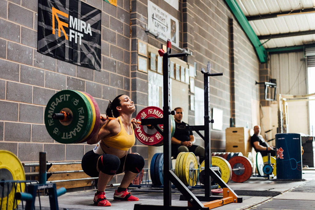 Mirafit M3 15kg Women's Olympic Barbell Team GB Olympic Weightlifter Sarah Davies performing a women's Olympic Barbell Back Squat with Mirafit Weight Plates