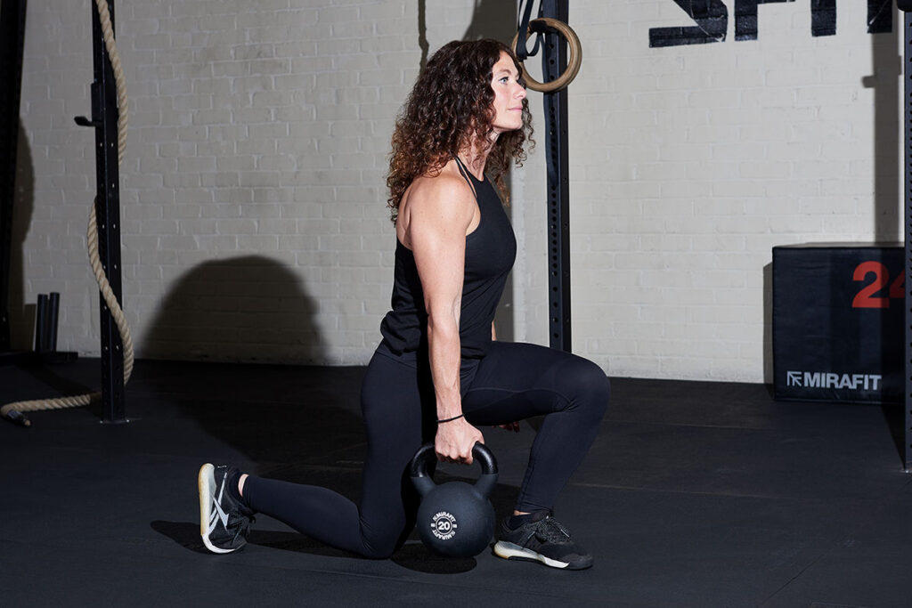 Mirafit Soft Touch Cast Iron Kettlebell - 20kg Kettlebell Woman performing contralateral split squats with a Mirafit 20kg kettlebell