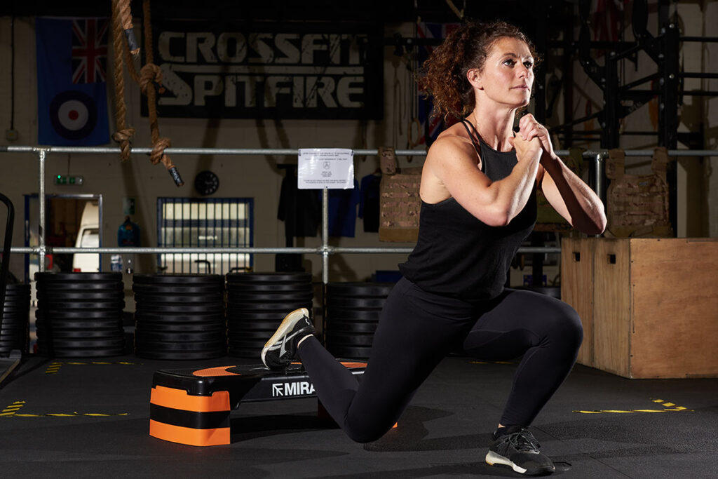 Bulgarian split squats A woman at a gym performing bulgarian split squats on a Mirafit Aerobic Exercise Step