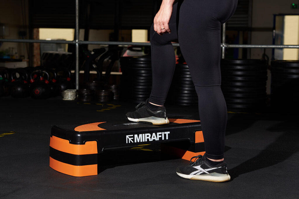 Mirafit Aerobic Exercise Step A woman at a gym steps onto a Mirafit Aerobic Exercise Step