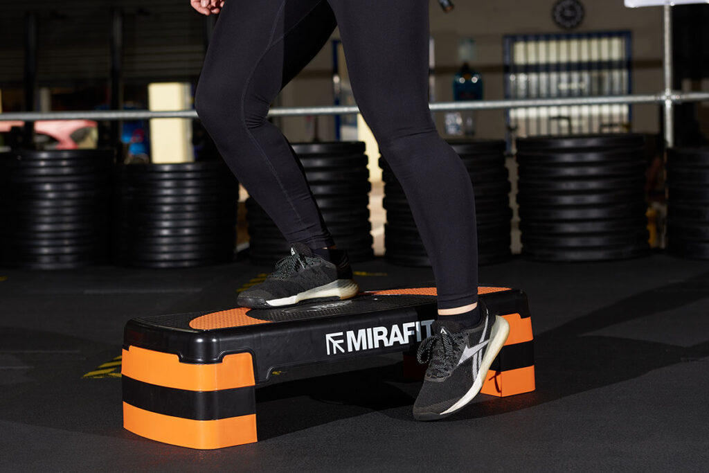 Up and over A woman performing an up and over with a Mirafit Aerobic Exercise Step
