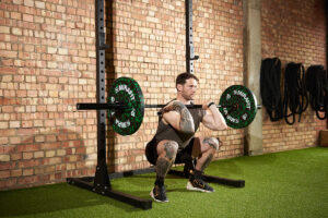 Fitness expert performing a front squat with a Mirafit Olympic barbell and 10kg weight plates