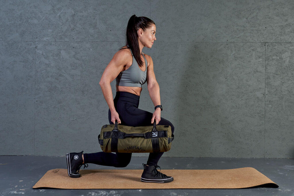 Side lunge Woman performing a side lunge with a Mirafit Multi Grip Workout Sandbag