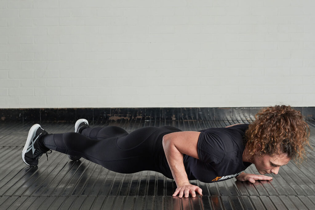 Woman doing a push up in a Mirafit shirt