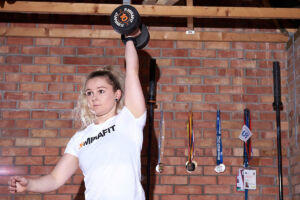 Woman lifting a Mirafit 10kg dumbbell