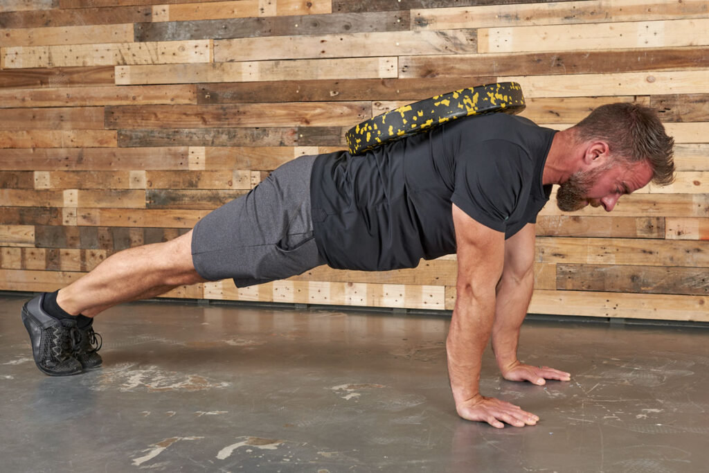 Man performing a plated push up with a Mirafit 15kg Weight Plate