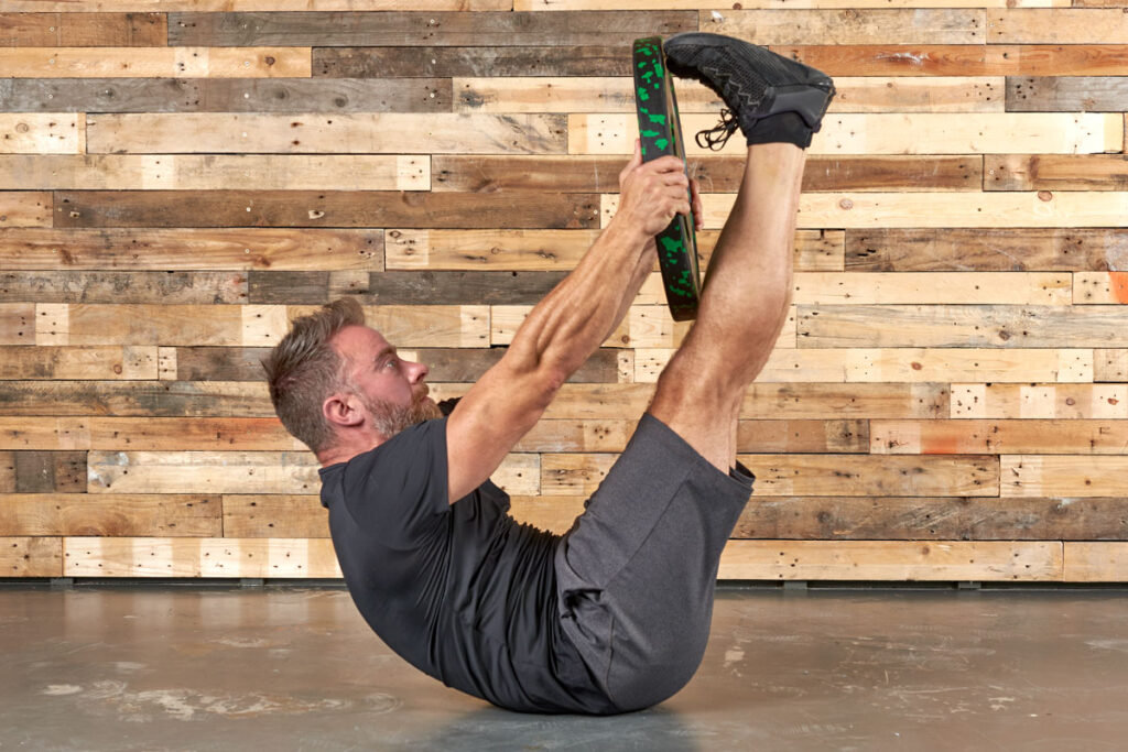 Man performing a toe tap with a Mirafit 15kg Weight Plate