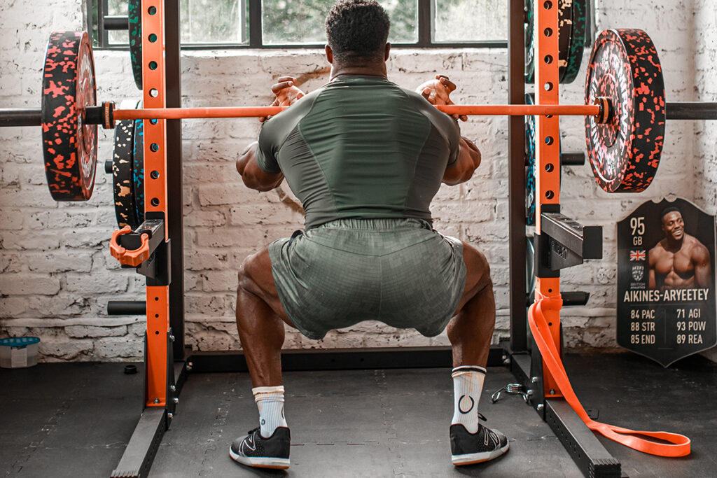 Mirafit M200 Power Rack Team GB Olympic Sprinter Harry AA front squatting with a Mirafit Olympic barbell