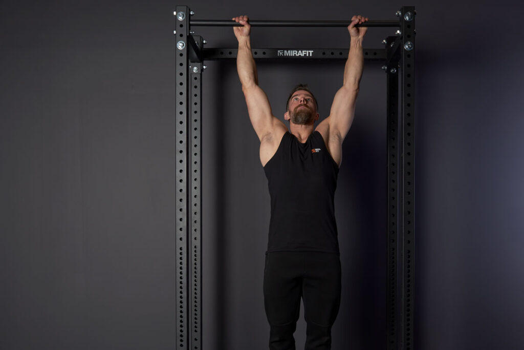 Mirafit M3 Power Rack Man Performing a Pull Up Using a Mirafit M3 Pull Up Bar on a power cage