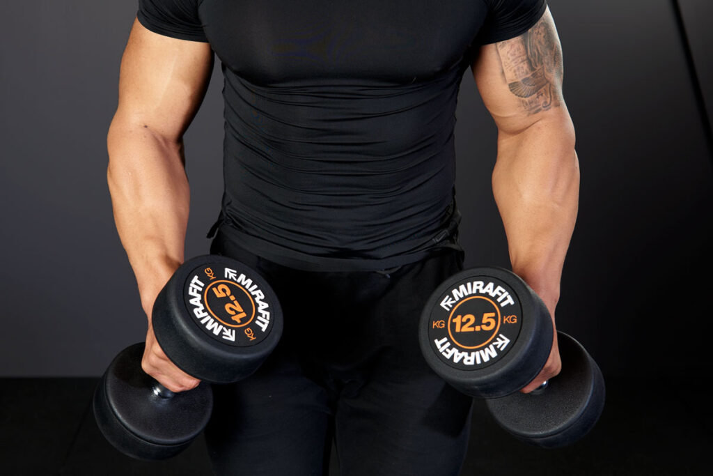 Mirafit Rubber Dumbbell Set - 12.5kg Dumbbells Man performing dumbbell lat raises with Mirafit 12.5kg dumbbells
