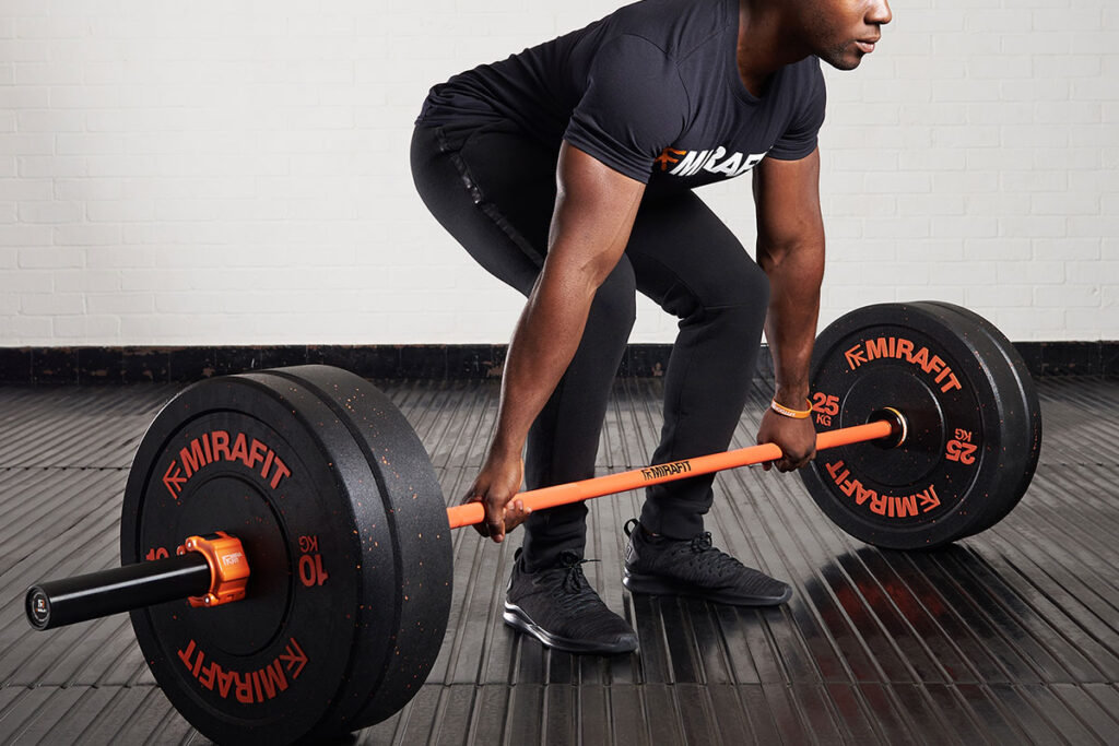 Fitness Professional Deadlifting with a Mirafit M3 7ft 20kg Cerakote Olympic Barbell in Black and Orange.